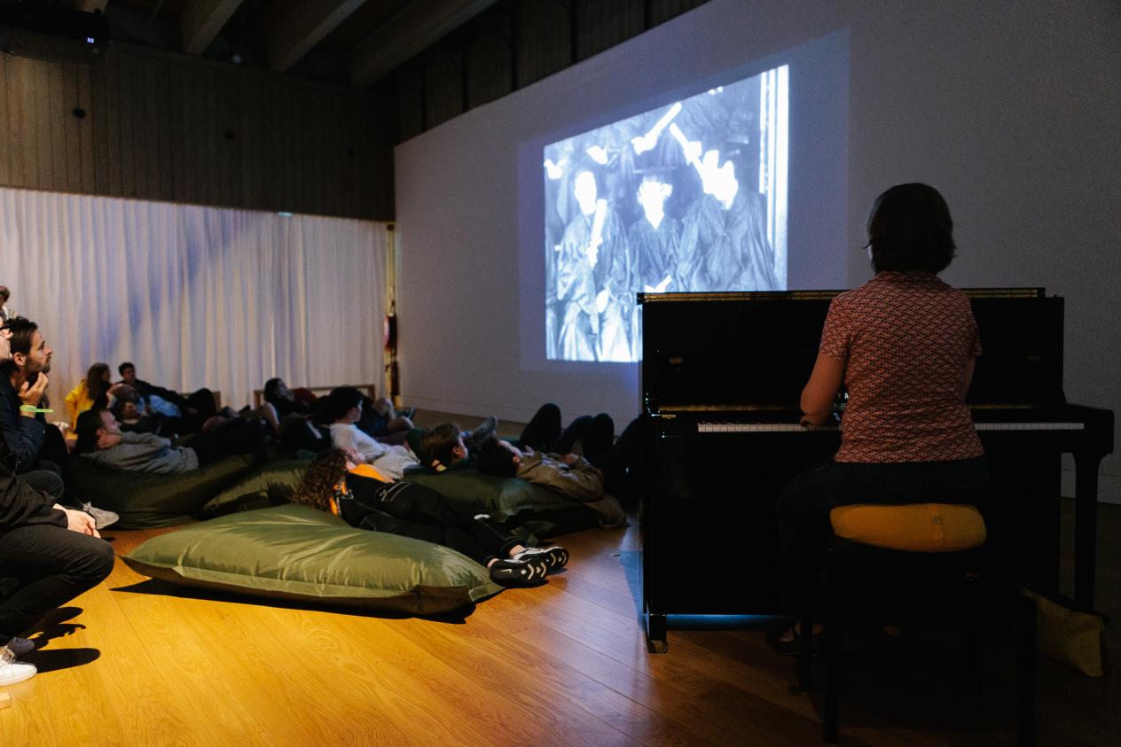 Mensen kijken naar een stille film met live piano