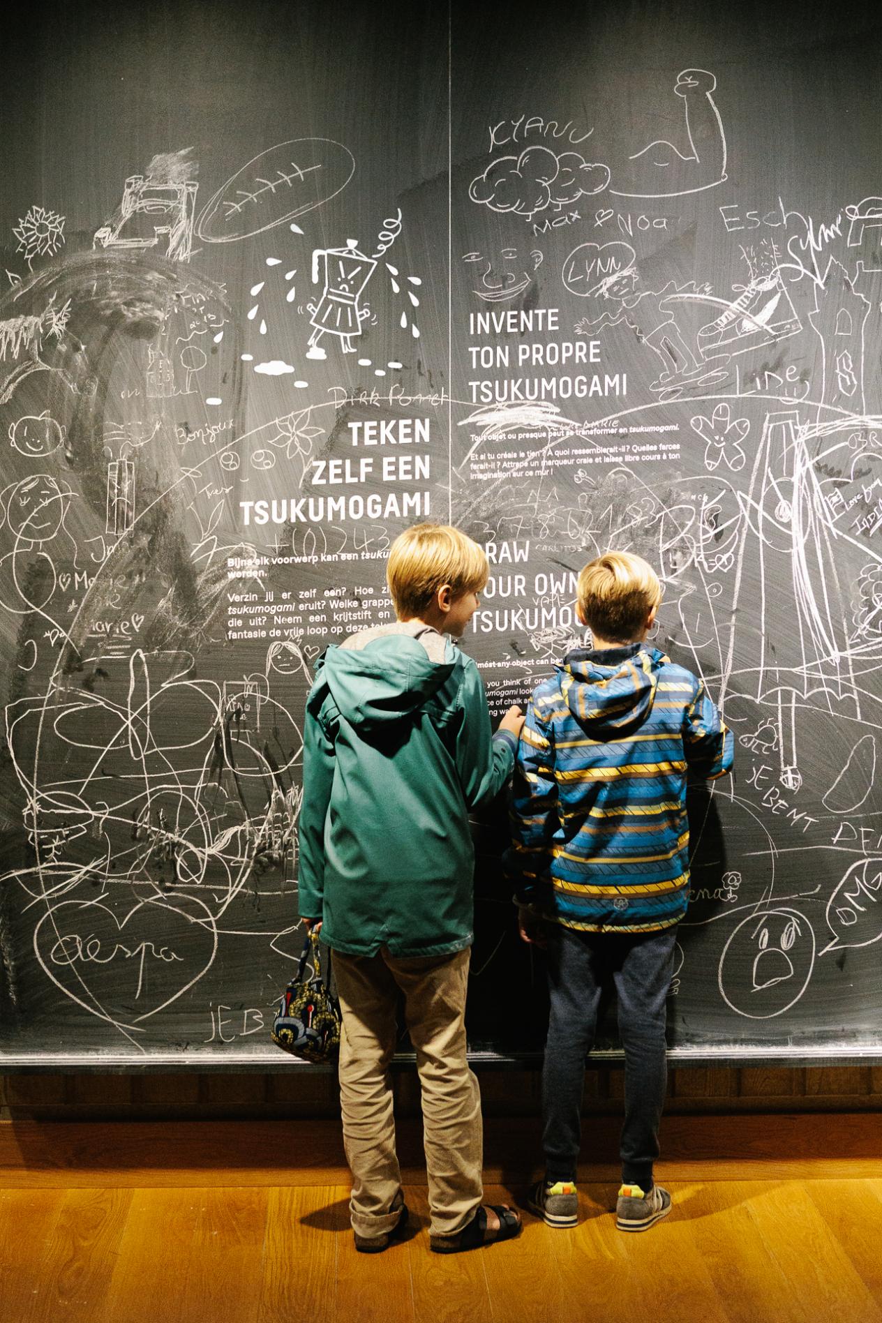 Twee kinderen tekenen op een krijtmuur