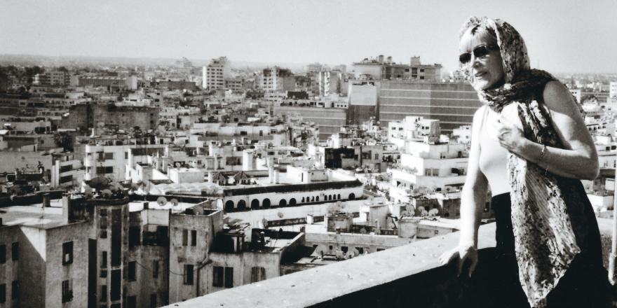 Zwart wit foto van Corinne die vanop terras naar een stad kijkt