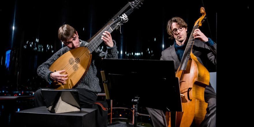 Twee muzikanten bespelen strijkinstrumenten theorbe en violone