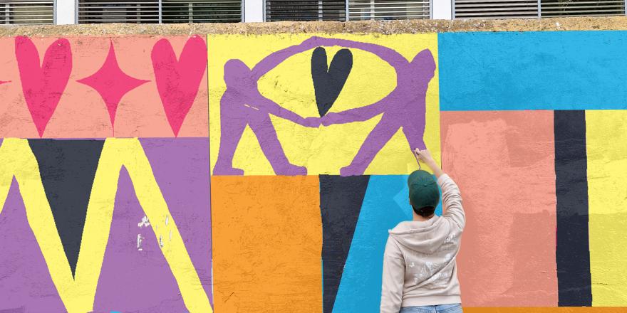 Persoon werkt aan kleurrijke muurschildering over queer verbondenheid