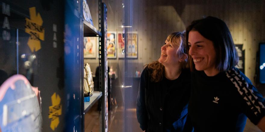 Twee vrouwen bekijken martial arts objecten in de tentoonstelling.