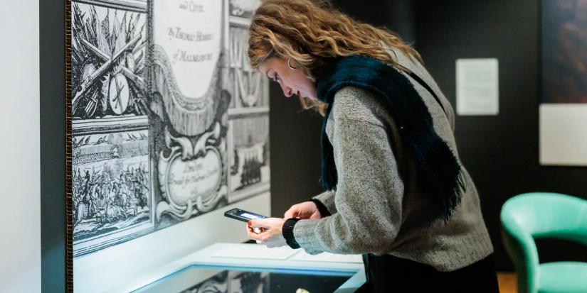 Bezoeker neemt foto van object in expo Compassion