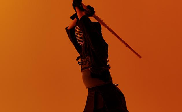 Kendo-beoefenaar heft bamboezwaard in aanvalshouding