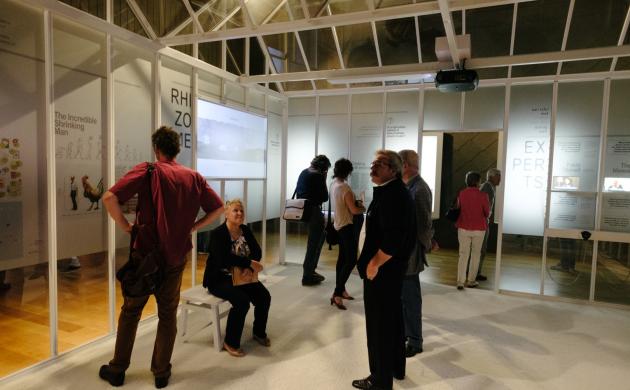 mensen staan onder een houten skelet van een huis