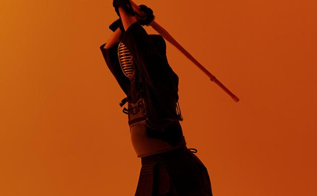 Kendo-beoefenaar heft bamboezwaard in aanvalshouding