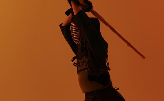 Kendo-beoefenaar heft bamboezwaard in aanvalshouding