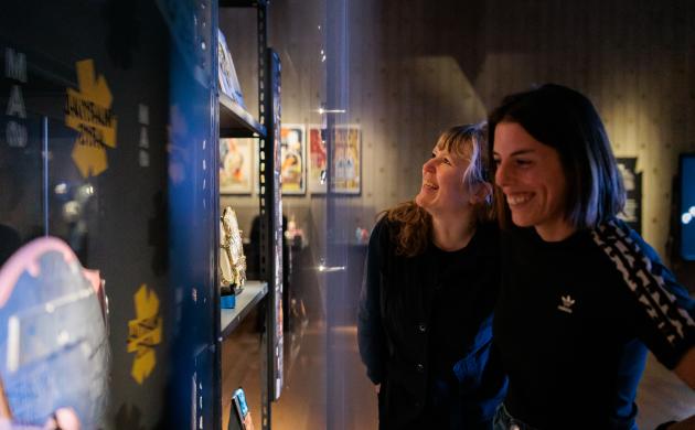 Twee vrouwen bekijken martial arts objecten in de tentoonstelling.