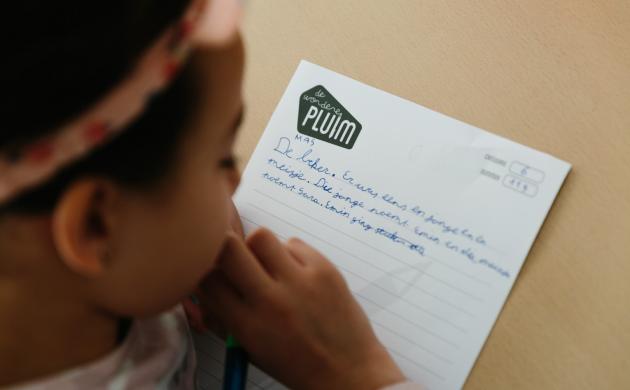 Schrijfdag De Wondere Pluim kind kijkt op blad papier