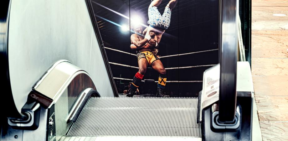 Roltrap voor een grote poster van een worstelwedstrijd.