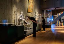 Bezoeker bekijkt historische harnassen in een museumzaal.